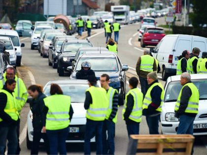 Demonstrators wearing a Yellow Vest (Gilet jaune) block the road during a protest against