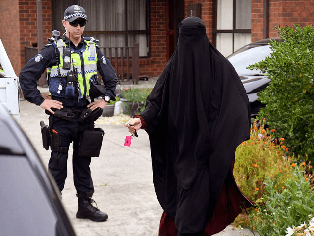 Media question a woman as she enters a house raided by police in the Melbourne suburb of Dallas on November 20, 2018. - Three men who allegedly plotted 'chilling' terror attacks in Melbourne were arrested early November 20, less than two weeks after a stabbing rampage inspired by the Islamic …
