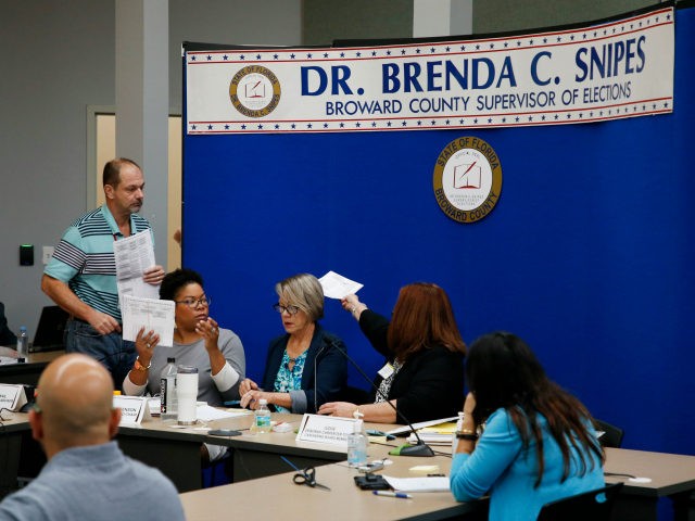Members of the canvassing board for the Broward County Supervisor of Elections Office revi