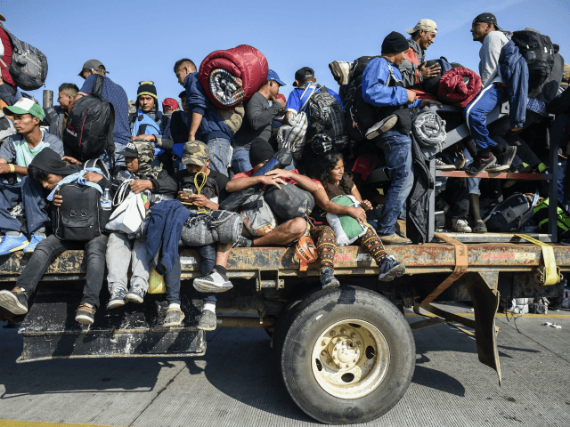 TOPSHOT - Central American migrants -mostly honduran- taking part in a caravan to the US, are pictured on board a truck heading to Irapuato in the state of Guanajuato on November 11, 2018 after spending the night in Queretaro in central Mexico. - The United States embarked Friday on a …