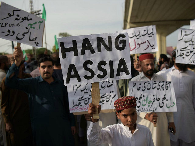 Supporters of Tehreek-e-Labaik Pakistan (TLP), a hardline religious political party hold placards as they march during a protest in Rawalpindi on October 12, 2018, demanding for hanging to a blasphemy convict Christian woman Asia Bibi, who is on death row. - Religious hardliners in Pakistan on October 10 threatened judges …