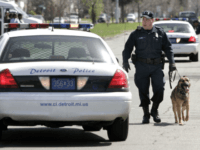 detroit police Officer Stephen Speil of the Detroit Police Department's K-9 Unit takes his bomb-sniffing dog 'Radar' to check parked vehicles for explosives at the funeral of rapper Deshaun 'Proof' Holton April 19, 2006 in Detroit, Michigan. Proof's funeral was attented by several thousand people. His solid bronze, 24K gold-plated casket cost …