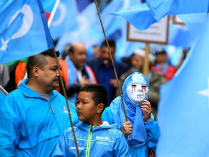 Ethnic Uighurs take part in a protest march asking for the European Union to call upon Chi