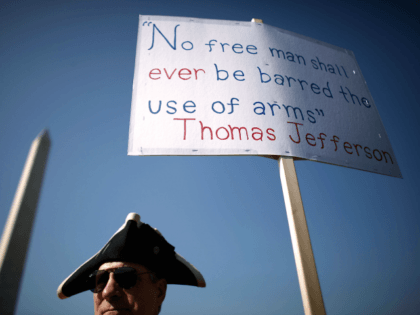 A man stands next to a sign pro-gun rally organized by the Second Amendment March group, n