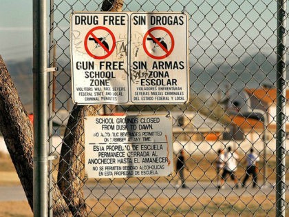 Drug and gun free school zone signs are shown as students play basketball at an elementary school Tuesday, Dec. 14, 2004, in Phoenix. Parents trying to get reports on violence and drugs at their kid's schools stand a good chance of having their intentions examined when they ask for public …