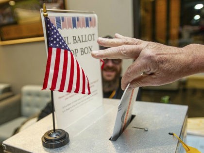 A voter drops an election ballot off at the Pitkin County Administration box in Aspen, Colo., on Tuesday Nov. 6, 2018. (Anna Stonehouse/The Aspen Times via AP)