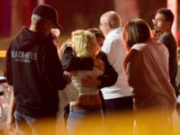 People comfort each other as they stand near the scene Thursday, Nov. 8, 2018, in Thousand Oaks, Calif., where a gunman opened fire Wednesday inside a country dance bar crowded with hundreds of people on "college night," wounding multiple people including a deputy who rushed to the scene. (AP Photo/Mark …