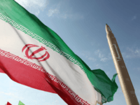 iran missile A picture taken on August 20, 2010 shows an Iranian flag fluttering at an undisclosed location in the Islamic republic next to a surface-to-surface Qiam-1 (Rising) missile which was test fired a day before Iran was due to launch its Russian-built first nuclear power plant. Iranian Defence Minister Ahmad Vahidi …