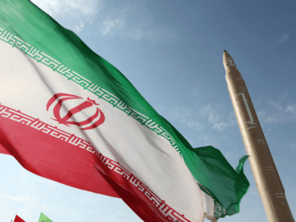 A picture taken on August 20, 2010 shows an Iranian flag fluttering at an undisclosed location in the Islamic republic next to a surface-to-surface Qiam-1 (Rising) missile which was test fired a day before Iran was due to launch its Russian-built first nuclear power plant. Iranian Defence Minister Ahmad Vahidi …