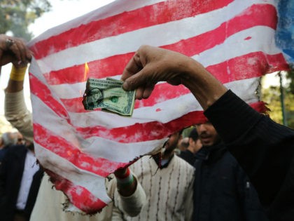 On the eve of renewed sanctions by Washington, Iranian protesters burn a dollar banknote a