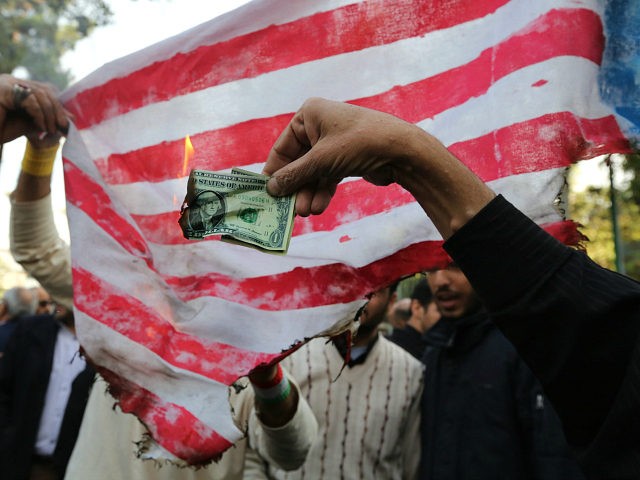 On the eve of renewed sanctions by Washington, Iranian protesters burn a dollar banknote a