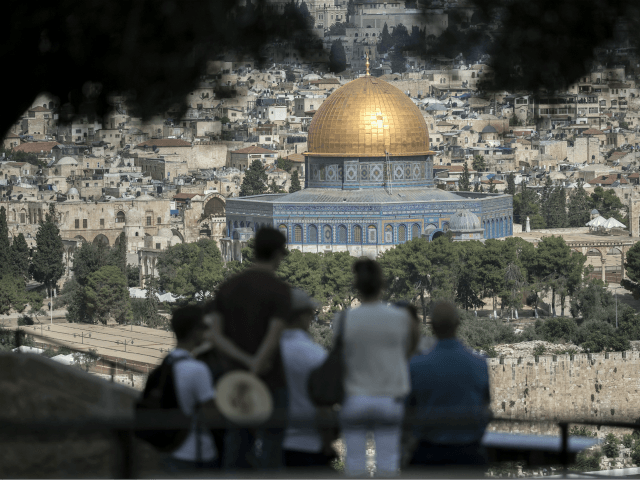 Tourists listen to a guide during a visit at Mount of Olives in east Jerusalem overlooking the Old City and the Dome of the Rock mosque, situated at the Al-Aqsa mosque compound, on June 28, 2016. Israeli authorities announced they were closing Jerusalem's flashpoint Al-Aqsa mosque compound to non-Muslim visitors …