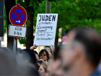 A protester holds a placard during the 'Berlin wears kippa' event, with more than 2,000 Jews and non-Jews wearing the traditional skullcap to show solidarity with Jews on April 25, 2018 in Berlin after Germany has been rocked by a series of anti-Semitic incidents. - Germans stage shows of solidarity …