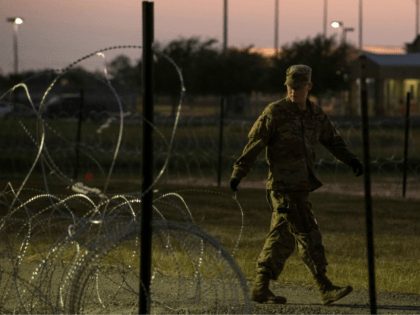 A US Army soldier closes a razor-wire gate at a compound where the military is erecting an encampment near the US-Mexico border crossing at Donna, Texas, on November 6, 2018. (Photo by Andrew Cullen / AFP) (Photo credit should read ANDREW CULLEN/AFP/Getty Images)