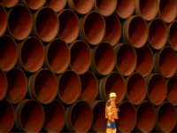 A worker walks in front of pipes which lie stacked at the Nord Stream 2 facility at Mukran on Ruegen Islandon October 19, 2017 in Sassnitz, Germany. Nord Stream is laying a second pair of offshore pipelines in the Baltic Sea between Vyborg in Russia and Greifswald in Germany for …