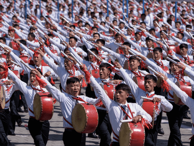Students march past a balcony from where North Korea's leader Kim Jong Un was watching, during a mass rally on Kim Il Sung square in Pyongyang on September 9, 2018. - North Korea held a military parade to mark its 70th birthday, but refrained from showing off the intercontinental ballistic …
