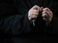 A Catholic worshipper holds a cross during an Ash Wednesday mass at Beijing's government-sanctioned South Cathedral in February