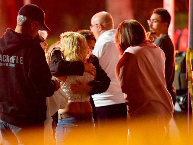 People comfort each other as they stand near the scene Thursday, Nov. 8, 2018, in Thousand Oaks, Calif., where a gunman opened fire Wednesday inside a country dance bar crowded with hundreds of people on "college night," wounding multiple people including a deputy who rushed to the scene. (AP Photo/Mark …