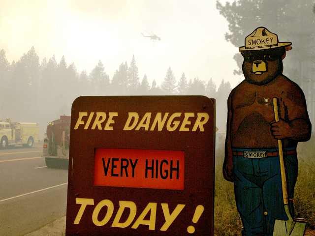 SOUTH LAKE TAHOE, CA - JUNE 26: A Smokey the Bear sign is seen as firefighters battle the Angora fire as it approaches homes June 26, 2007 in South Lake Tahoe, California. Firefighters continue to battle the 2,700 acre Angora wildfire near Lake Tahoe that has consumed over 200 structures. …
