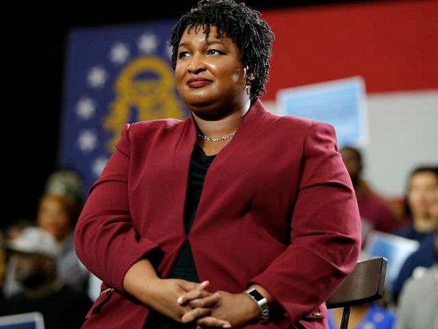 Georgia gubernatorial candidate Stacey Abrams watch as former President Barack Obama speak