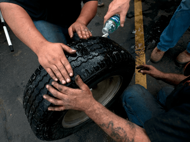 Tom Burkhart, and Johnnie Harrison, of Karnes Pro Tire and Auto Center, fix flat tires of