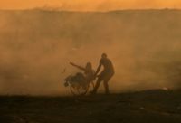 A Palestinian protester in a wheelchair is pulled by a fellow demonstrator amid clouds of tear gas fired by Israeli forces during border clashes east of Gaza City on November 2, 2018