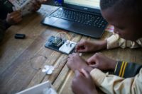 Pupils at the coding club in Ivory Park take wires from the breadboard -- the base for building an electronics circuit -- to a fan that they will programmme to work from a laptop