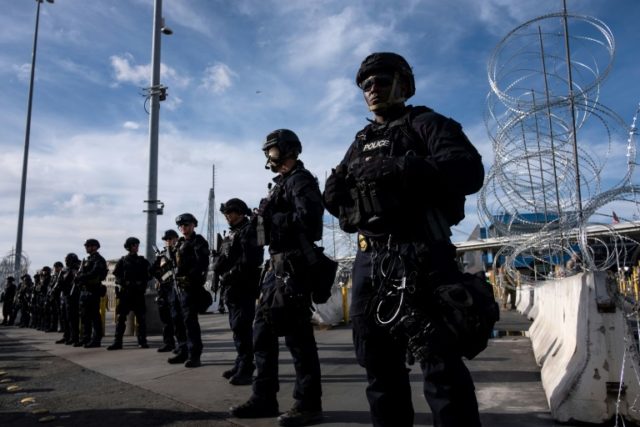 US border control agents stand in formation during a show of force as Central American migrants mass on the other side of the frontier Migrants defy Trump at Mexico border as US forces flex muscle