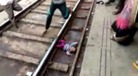 This screengrab taken from a video shot and provided by NNIS shows a baby girl next to train tracks after being dropped in the station in Uttar Pradesh state