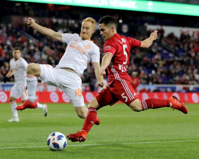 Connor Lade (R) of New York Red Bulls takes a shot as Jeff Larentowicz of Atlanta United defends in the first half during the Eastern Conference Finals Leg 2 match, at Red Bull Arena in Harrison, New Jersey, on November 29, 2018 Atlanta into MLS Cup after Red Bulls stalemate