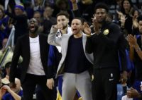 Golden State star Stephen Curry (C), cheering the Warriors on in a win over Orlando, will return from an 11-game injury absence against the Detroit Pistons on Saturday