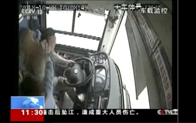 China Bus Accident In this image taken from Sunday, Oct. 28, 2018 surveillance video footage run by China's CCTV via AP Video, a passenger strikes a bus driver with an object moments before the bus plunged off a bridge into the Yangtze River in Wanzhou in southwestern China's Chongqing Municipality. Police say a brawl between a passenger and a bus driver was the cause of the bus plunging off a bridge and killing more than a dozen people in southwestern China on Sunday. (CCTV via AP Video) The Associated Press