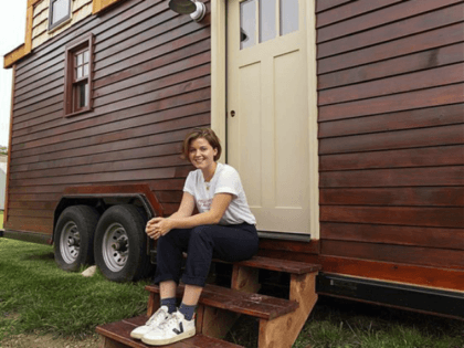 Meghan Panu sits on the front steps of her house in St. Louis. The 12-foot-tall house was