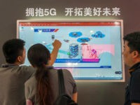 5G-technology-Mobile-World-Conference-China-18-Getty People watch a screen showing information on 5G technology during the Mobile World Conference in Shanghai on June 27, 2018. (Photo by - / AFP) / China OUT (Photo credit should read -/AFP/Getty Images)