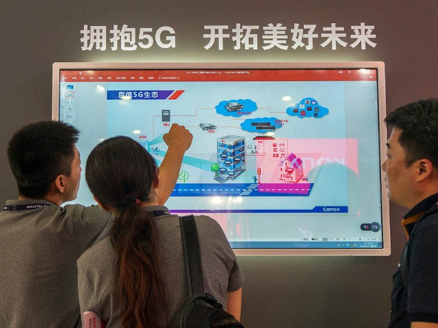 People watch a screen showing information on 5G technology during the Mobile World Conference in Shanghai on June 27, 2018. (Photo by - / AFP) / China OUT (Photo credit should read -/AFP/Getty Images)