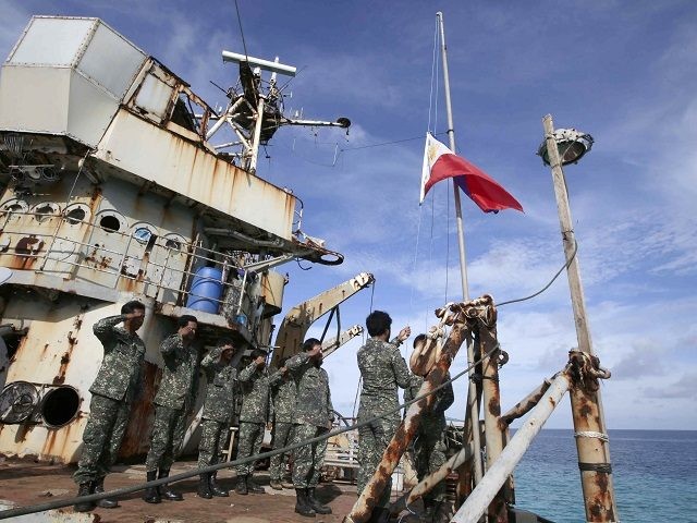 FILE - In this March 29, 2014, file photo, Philippine Marines deployed on the Philippine Navy ship LT 57 Sierra Madre practice the "relieving the watch" ceremony near Second Thomas Shoal in the South China Sea. In one of the world's most disputed waters, the puny Philippine navy doesn't stand …