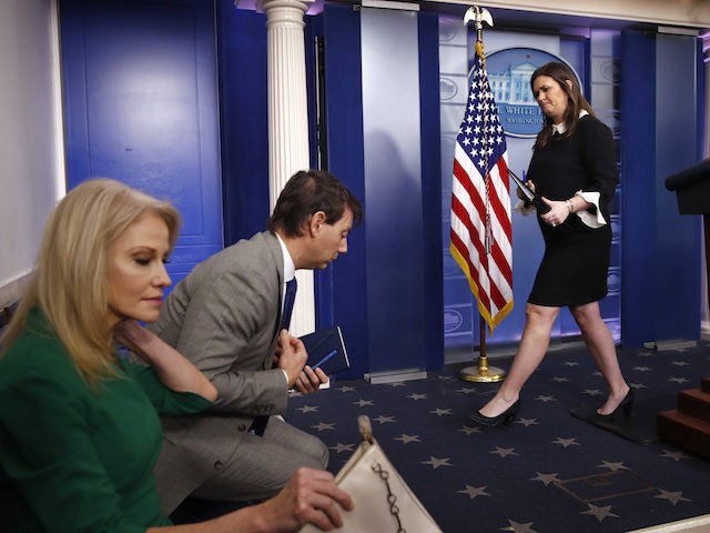 White House Press Secretary Sarah Huckabee Sanders, right, leaves the podium after a news