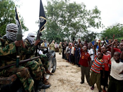 Hardline Islamist fighters from Al-Shabab parade past children as they rally in the street