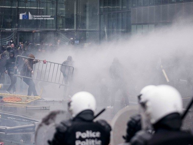 Protestors face off against the police during an anti-migrant demonstration outside of EU headquarters in Brussels, Sunday, Dec. 16, 2018. Police used tear gas and water cannons to disperse demonstrators around the European Union headquarters at the end of a march to protest the adoption of a U.N. migration pact. …