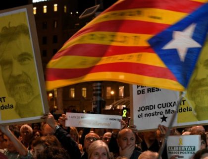 People hold placards reading 'We won´t give up' and a Catalan pro-independence 'estelada' during a demonstration in Barcelona on October 16, 2018, marking the one year anniversary of the detention of two grass-root Catalan separatist leaders, Jordi Sanchez and Jordi Cuixart. (Photo by LLUIS GENE / AFP) (Photo credit should …