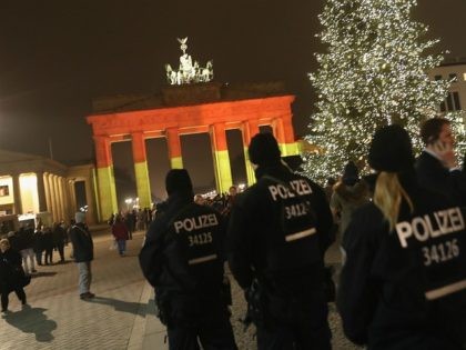 BERLIN, GERMANY - DECEMBER 20: The Brandenburg Gate stands illuminated in the colors of the German flag as police walk past the day after a truck drove into a crowded Christmas market in the city center on December 20, 2016 in Berlin, Germany. So far 12 people are confirmed dead …