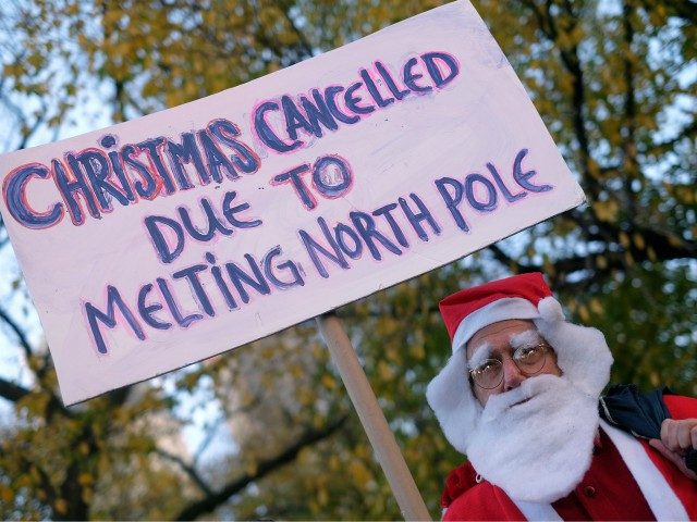 A man dressed as Santa Claus displays a placard during a rally calling for action on climate change in New York on November 29, 2015, a day before the start of the COP21 conference in Paris. Some 150 leaders, including US President Barack Obama, China's Xi Jinping, India's Narendra Modi …