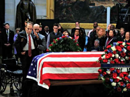 Former Sen. Bob Dole salutes the flag-draped casket containing the remains of former President George H.W. Bush as he lies in state at the U.S. Capitol in Washington, Tuesday, Dec. 4, 2018.