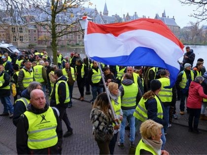 Dutch police lead a small group of yellow jacket protesters away from the Dutch Parliament in The Hague, Netherlands, on Saturday, Dec. 1, 2018. Police closed off the parliamentary complex after about 100 demonstrators gathered outside protesting government policy as the yellow vest movement spread into the Netherlands. (AP Photo/Mike …