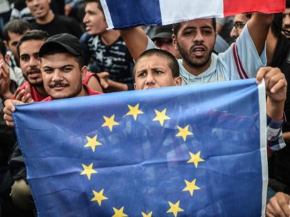A migrant holds an European Union flag as migrants and refugees stage a demonstration at Istanbul's Esenler Bus Terminal on September 19, 2015 after authorities withheld tickets to Turkish border towns. Hundreds of refugees camped out at the main bus station in Istanbul for a fifth night running after being …