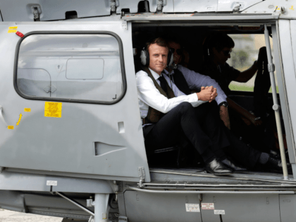 French President Emmanuel Macron looks out from a helicopter after landing on September 30