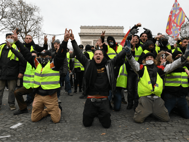 PARIS, FRANCE - DECEMBER 08: Demonstrators kneel and gesture with victory signs as they ta