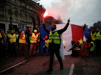Protestors wearing 'yellow vests' (gilets jaunes) wave a French flag as they dem