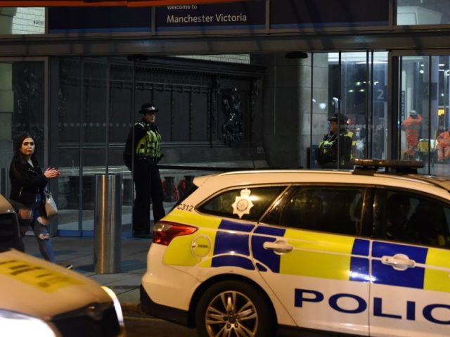 Police officers stand near a cordon at Manchester Victoria Station, in Manchester on January 1, 2019, following a stabbing on December 31, 2018. - A man, a woman and a police officer were being treated for knife injuries, police said Monday, after a stabbing at a railway station in the …