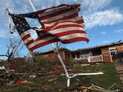 JOPLIN, MO - MAY 27: A torn American flag hangs on a pole outside of a house that was dam